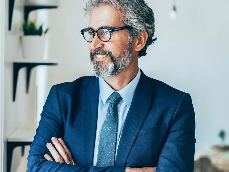 Man with glasses looking to the right smiling