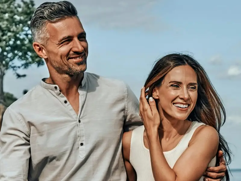 Younger couple looking to their left smiling